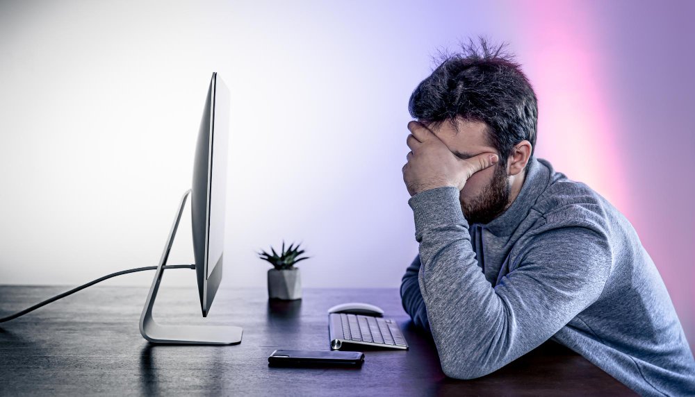 Persona preoccupata davanti al PC con disco diventato RAW dopo CHKDSK